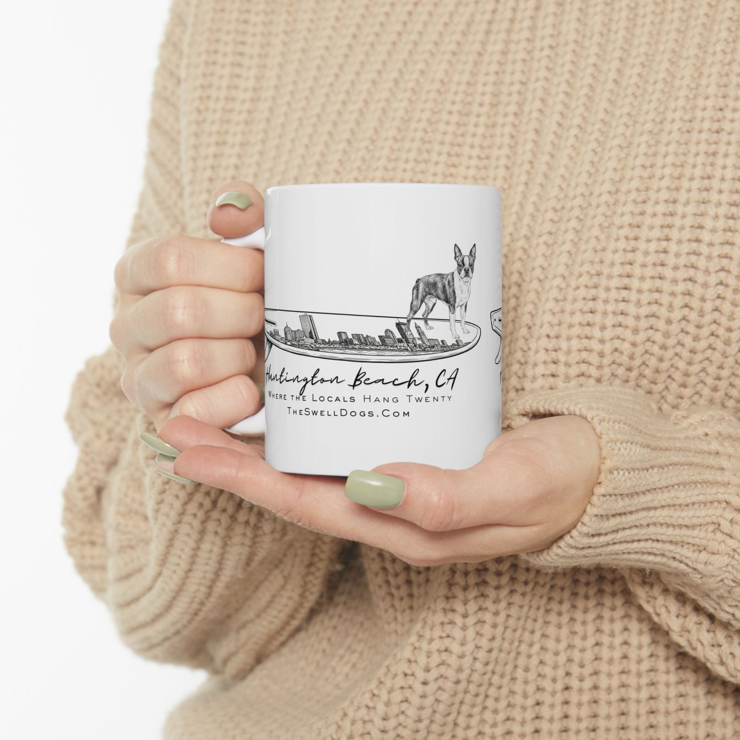 White mug: Boston Terrier surfing on a board detailed with the Boston skyline, "Huntington Beach, CA" text below.