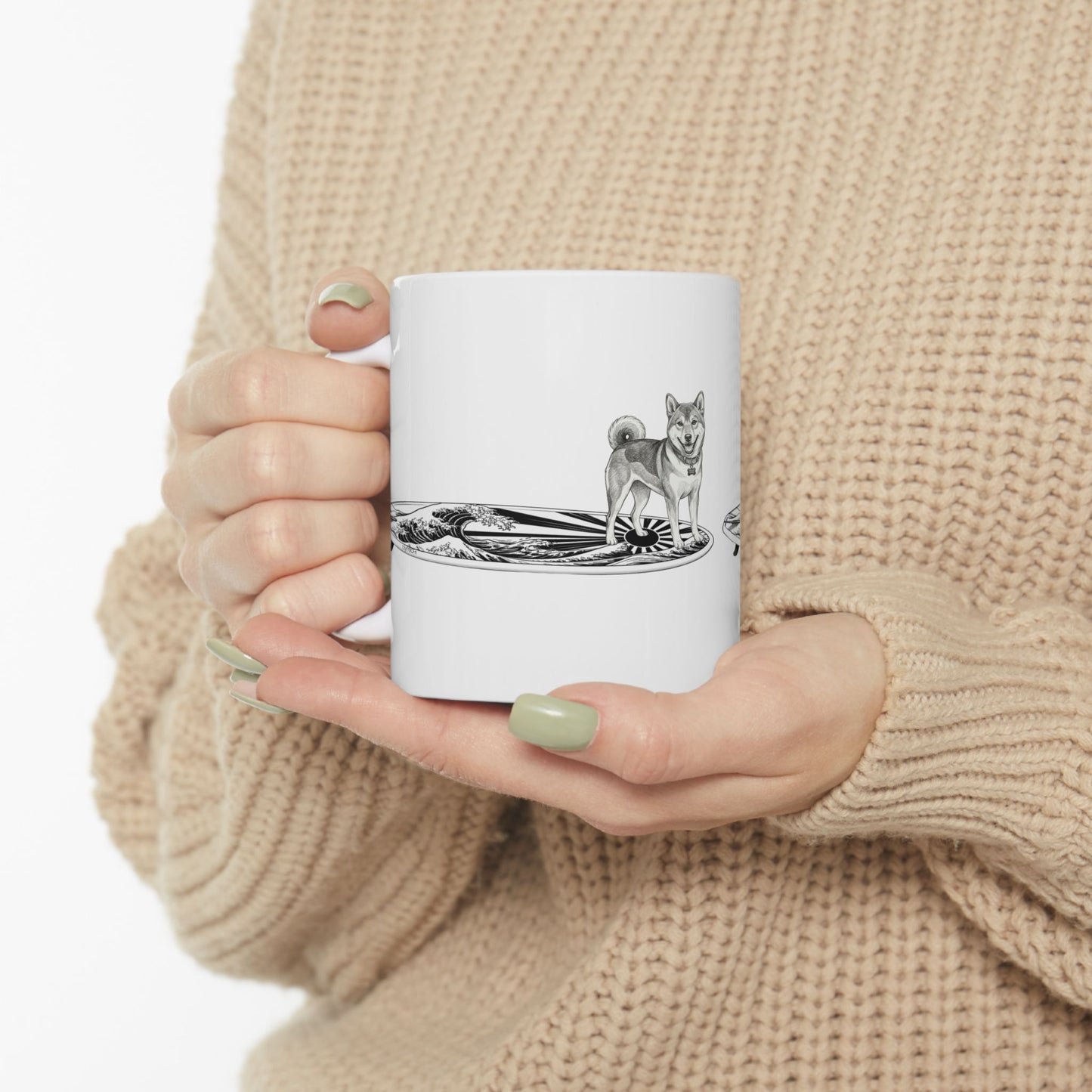 Woman in cozy sweater holding Shiba Inu surf mug with rising wave and Japanese sun flag design — The Swell Dogs