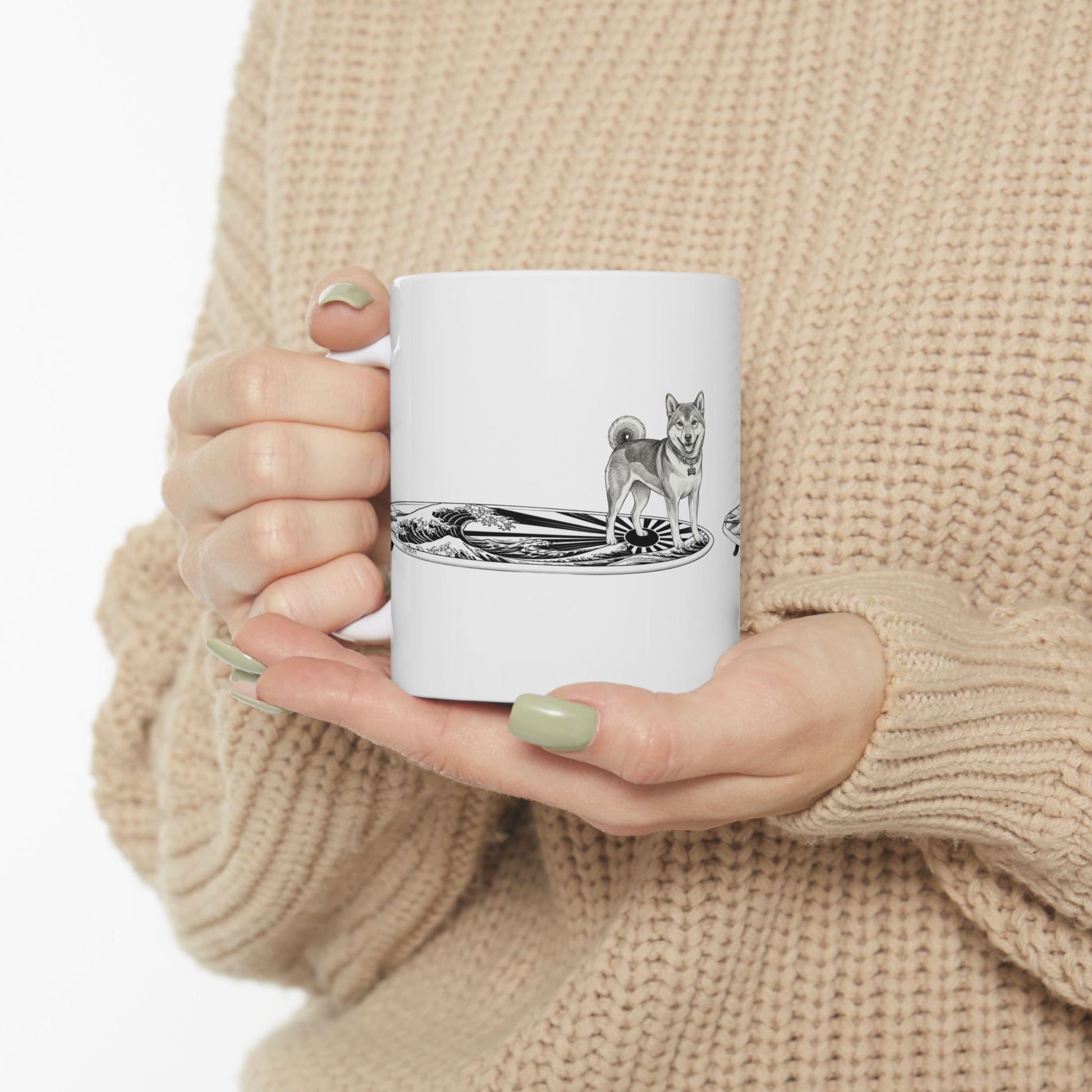 Woman in cozy sweater holding Shiba Inu surf mug with rising wave and Japanese sun flag design — The Swell Dogs