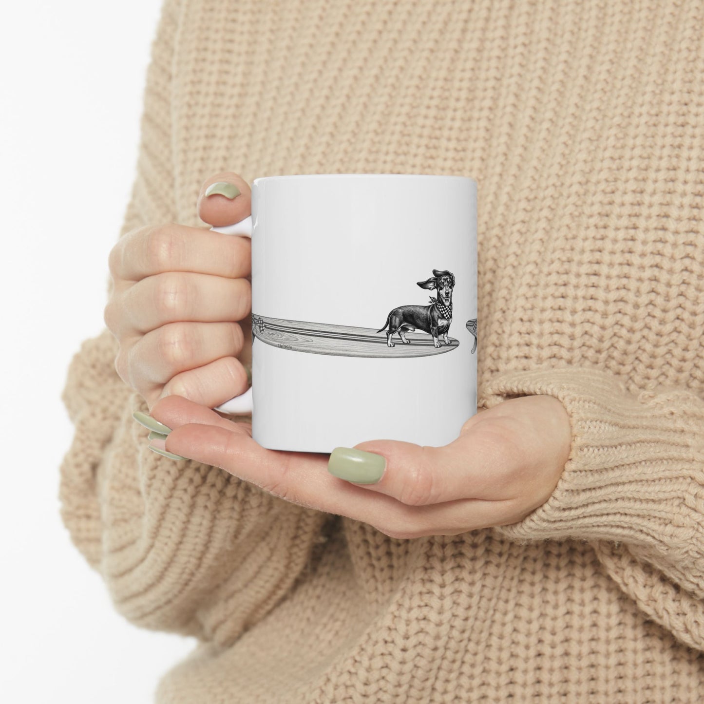 Woman in cozy sweater holding Dachshund surf mug featuring checkered racing flag bandana and wood grain surfboard line drawing — The Swell Dogs