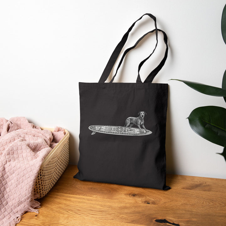 Black  tote bag with a Great Dane on a longboard with wild boar crests and suns on it.