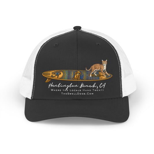 Adjustable trucker hat featuring a tabby cat standing on an Egyptian surfboard with "Huntington Beach, CA" text