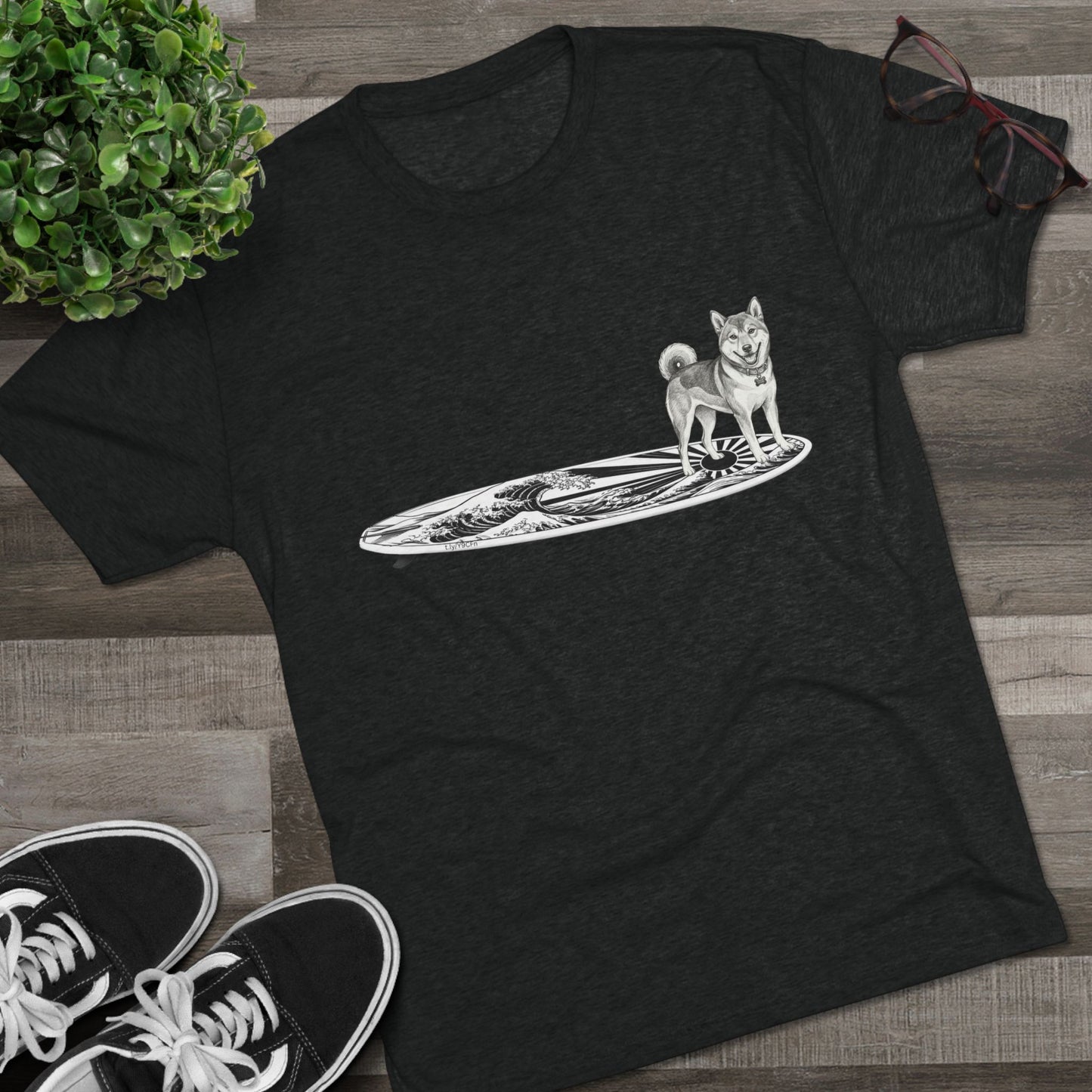 Black Shiba Inu surf t-shirt with rising wave and Japanese sun flag design styled on wood floor with Vans sneakers — The Swell Dogs
