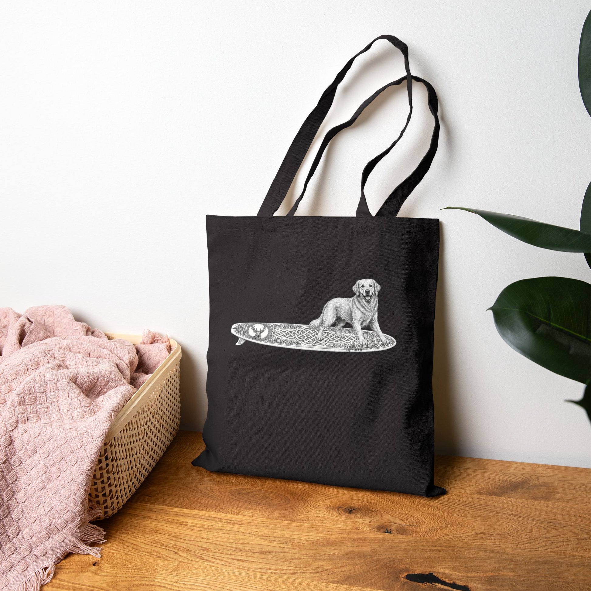 Black tote bag with a Golden Retriever riding a long surfboard with keltic knots and embellishments.