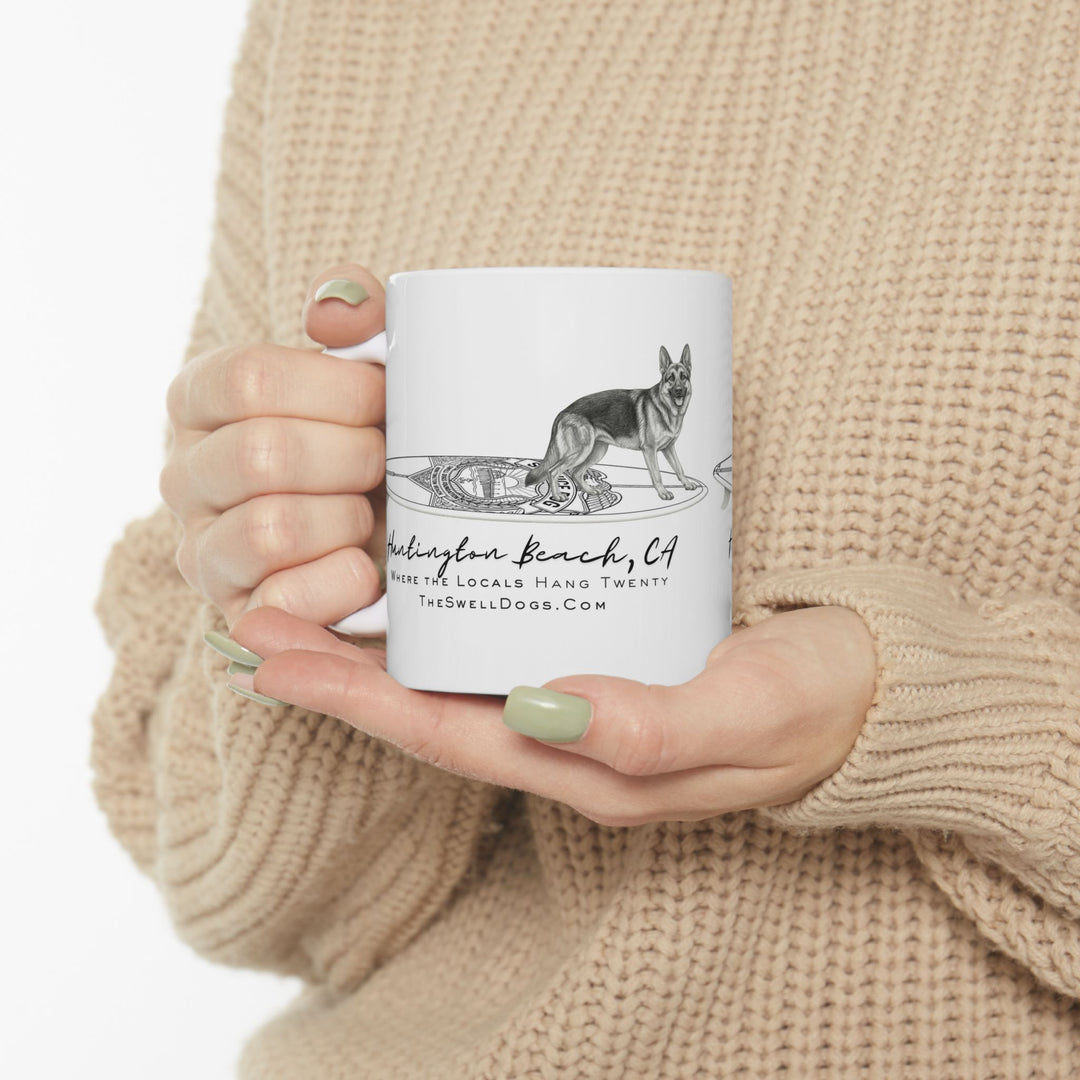 White mug featuring a German Shepard on a police surfboard with "Huntington Beach, CA" text