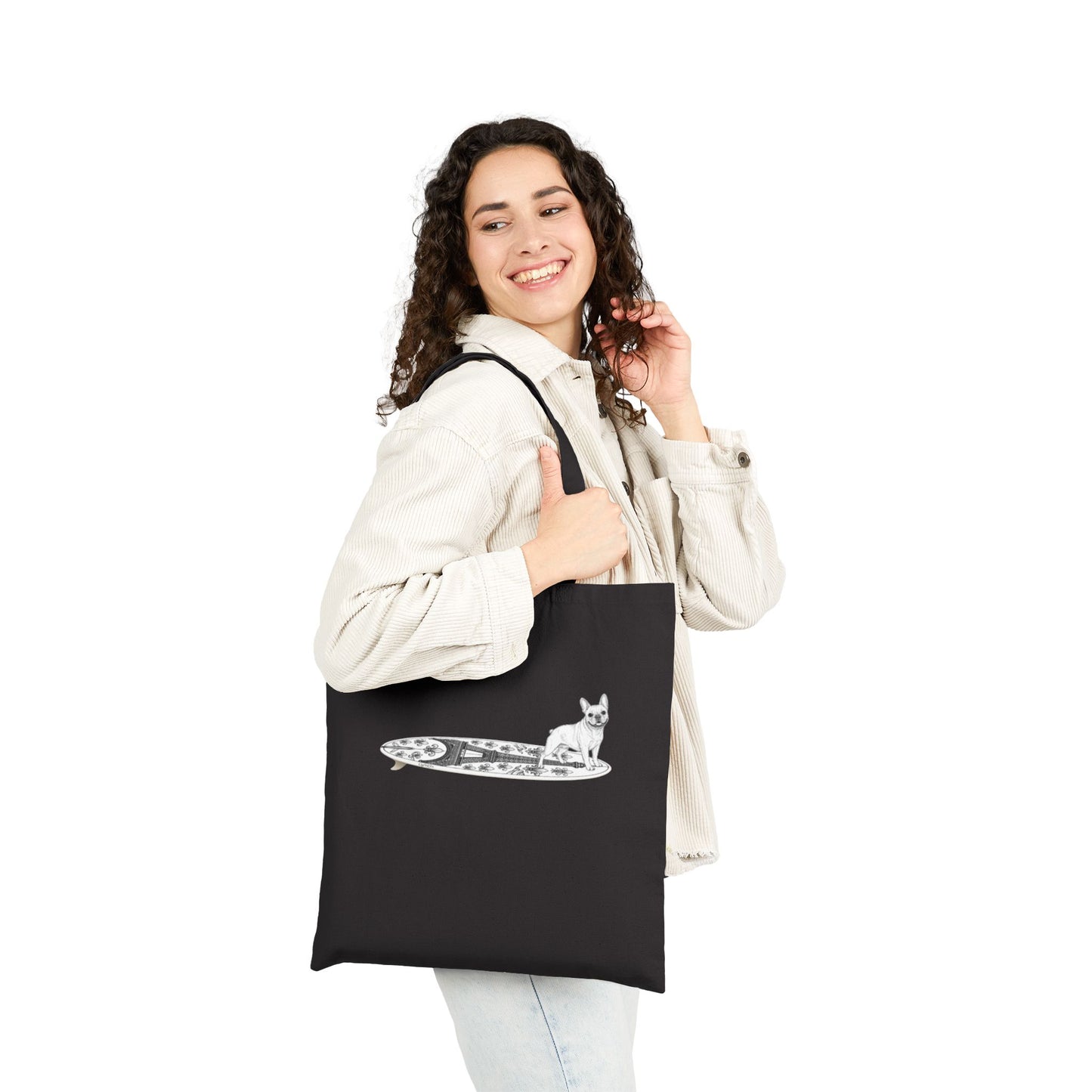 Woman holding a black  tote bag with a French Bulldog on an Eiffel Tower surfboard.