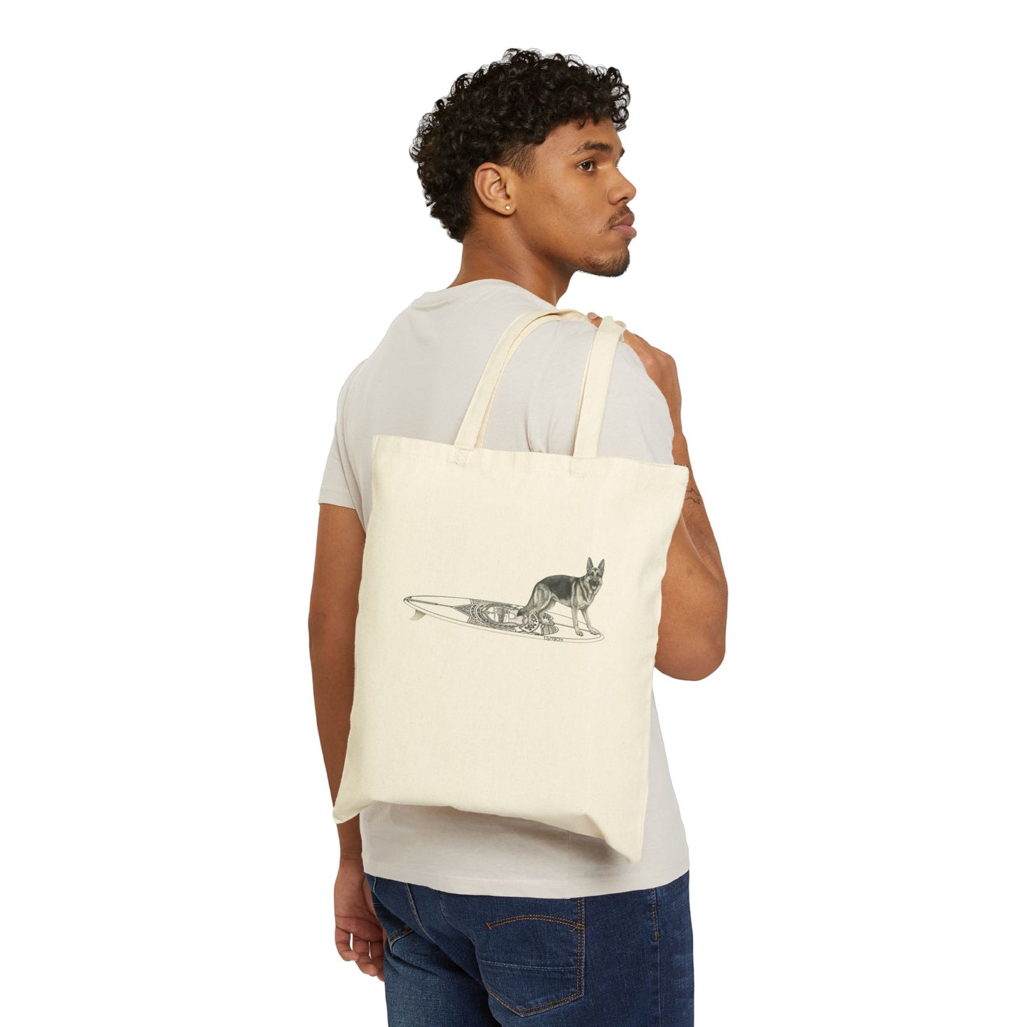 Man carrying a beige tote bag with a German Shepherd dog on a service dog long surfboard.