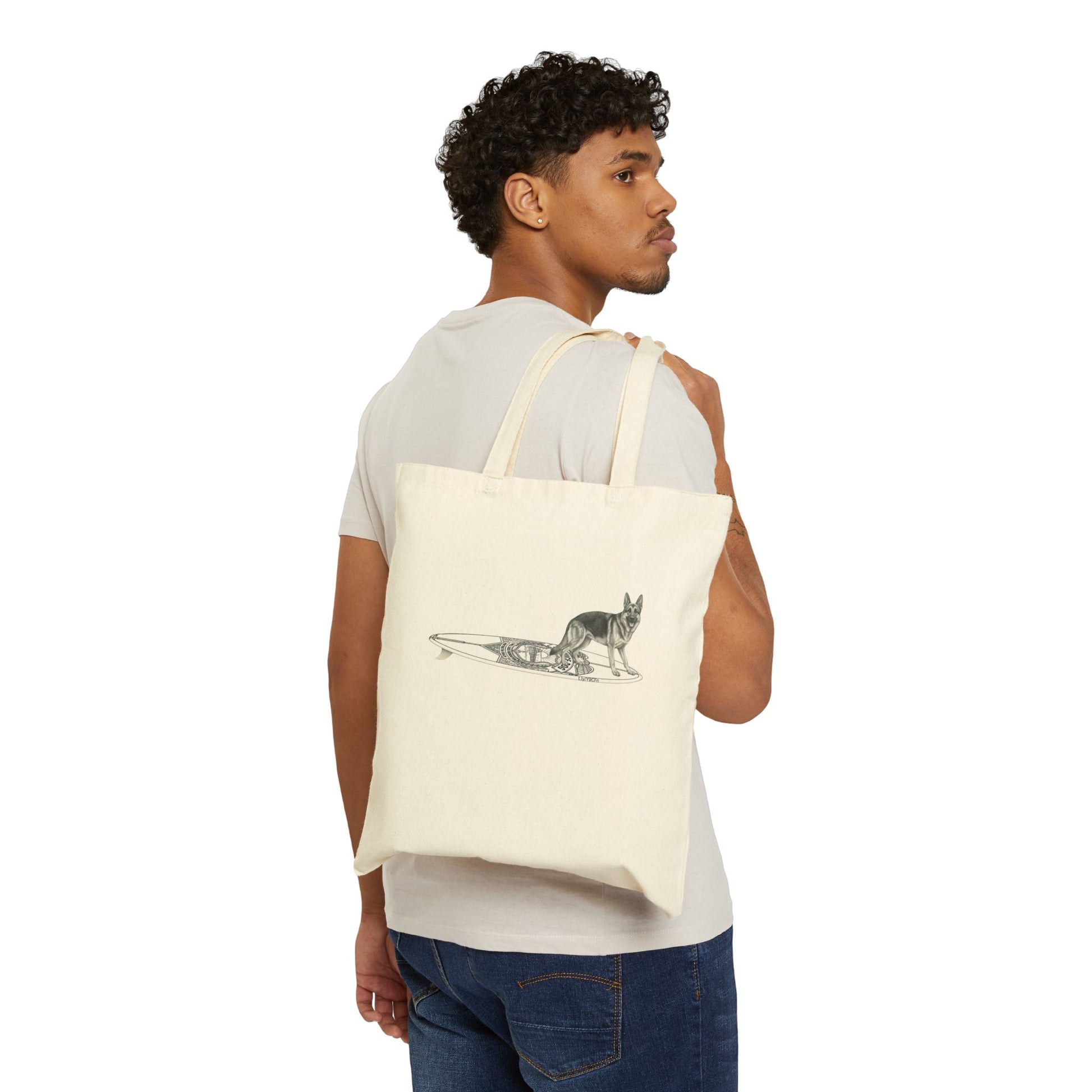 Man carrying a beige tote bag with a German Shepherd dog on a service dog long surfboard.