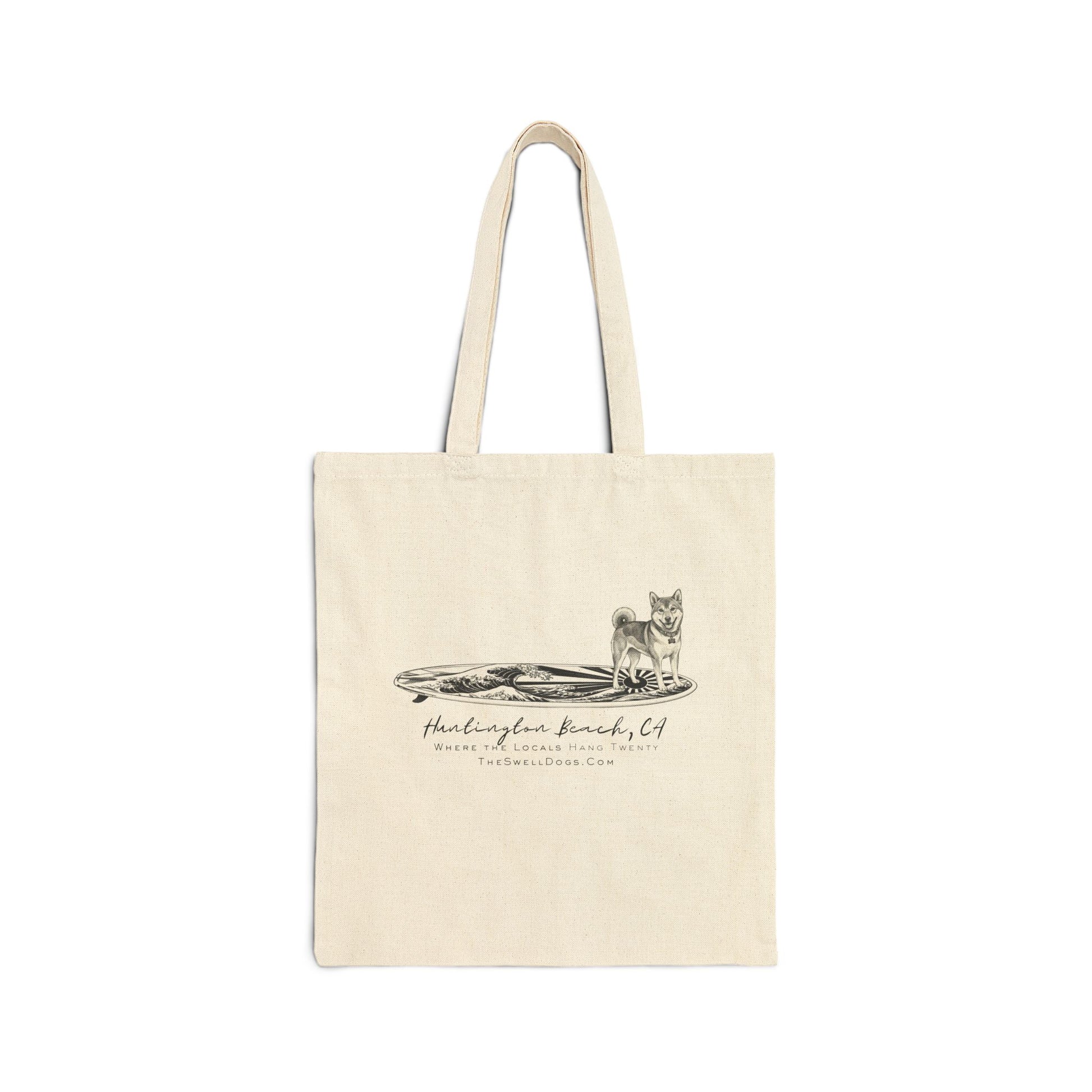 Beige tote bag featuring a Shiba Inu dog standing on a Japanese surfboard with "Huntington Beach, CA" text
