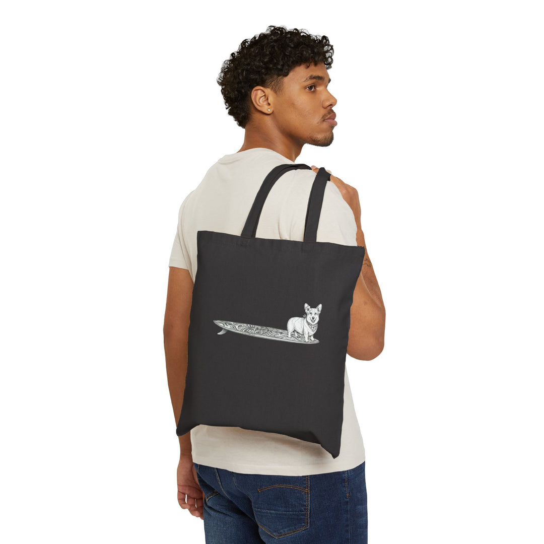 Man carrying black Corgi surf tote bag with hibiscus bandana tiki surfboard design over shoulder — The Swell Dogs