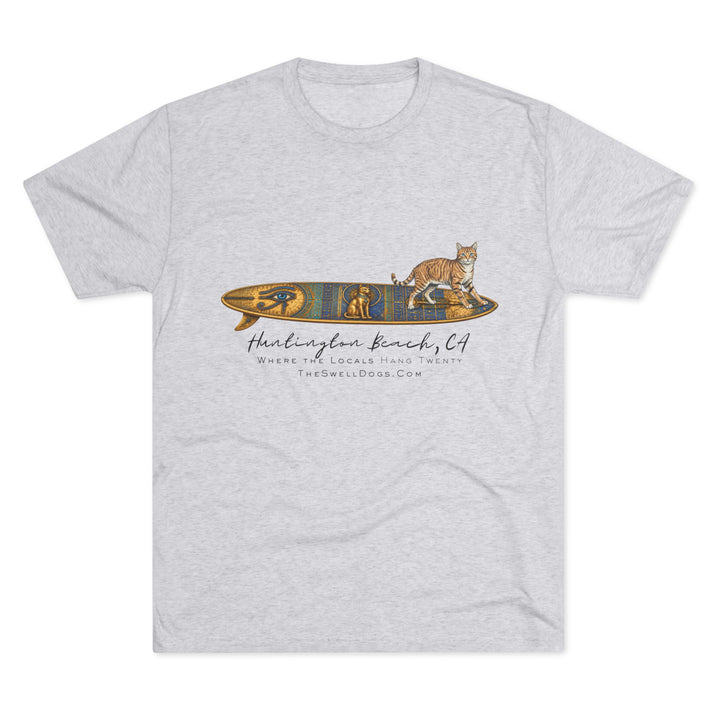 White t-shirt featuring a tabby cat standing on an Egyptian surfboard with "Huntington Beach, CA" text