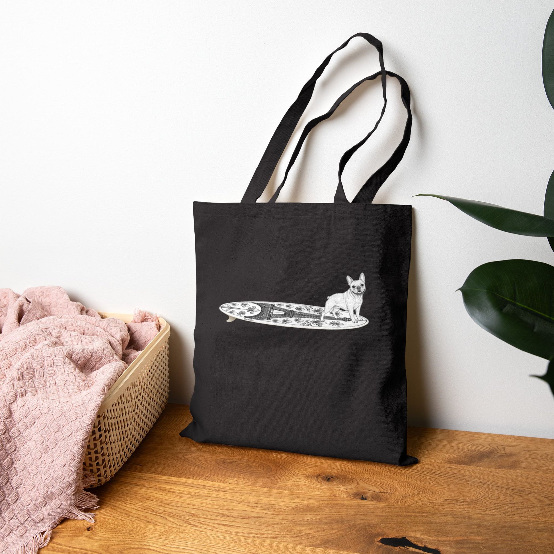 Black tote bag with a French Bulldog on an Eiffel Tower surfboard.