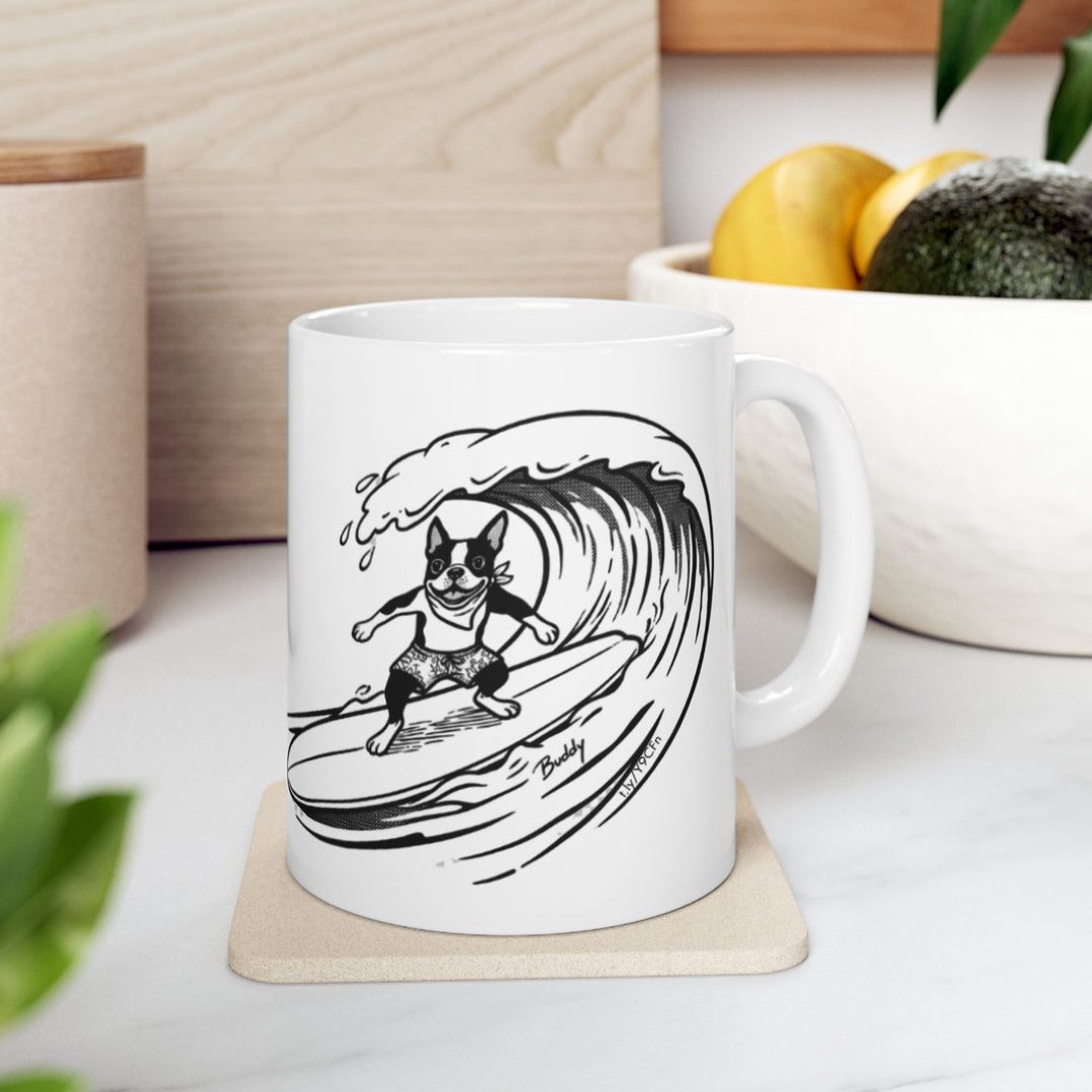 White mug with a black and white graphic of a Boston Terrier surfing on a big wave with a white background.