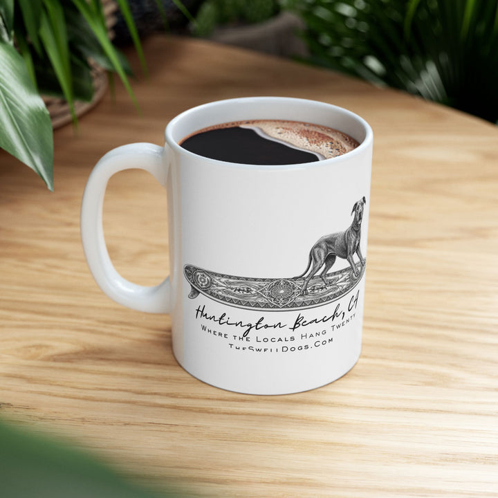 White mug filled with coffee featuring a Great Dane standing on a surfboard with "Huntington Beach, CA" text