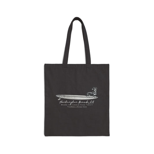 Black tote bag featuring a Dachshund dog standing on a surfboard with "Huntington Beach, CA" text