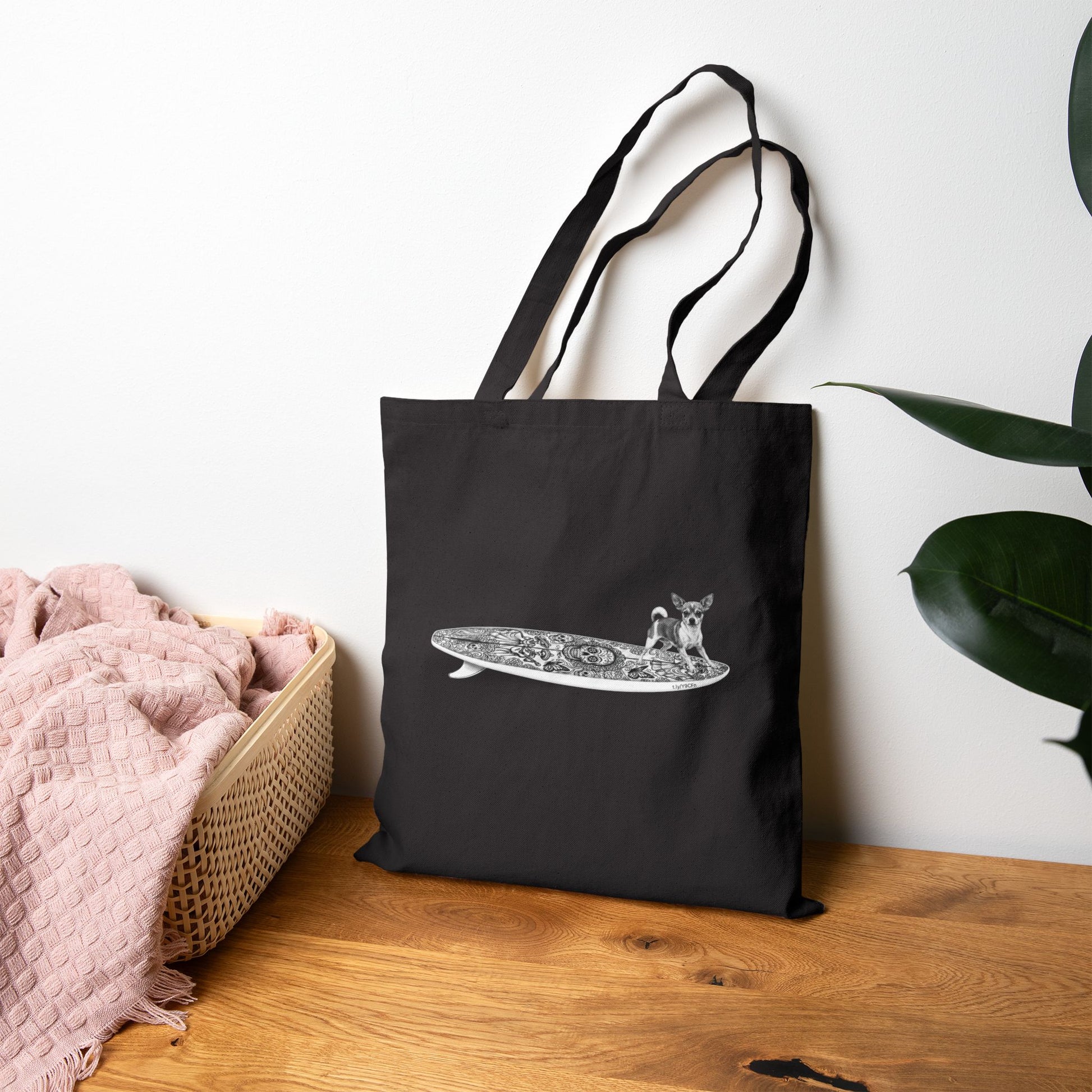 Black tote bag with a Chihuahua surfing on a Day of the Dead surfboard.