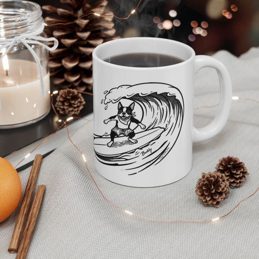 White mug with a black and white graphic of a Boston Terrier surfing on a big wave with a white background.