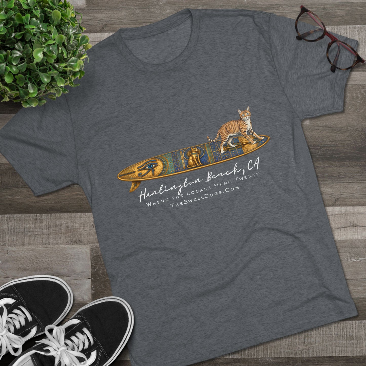Grey t-shirt featuring a tabby cat standing on an Egyptian surfboard with "Huntington Beach, CA" text