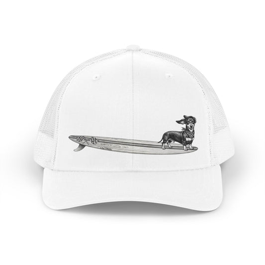 White  mesh trucker hat with a Dachshund dog on a longboard surfboard with racing flags on it. The dog has a checkered bandana around it's neck. 