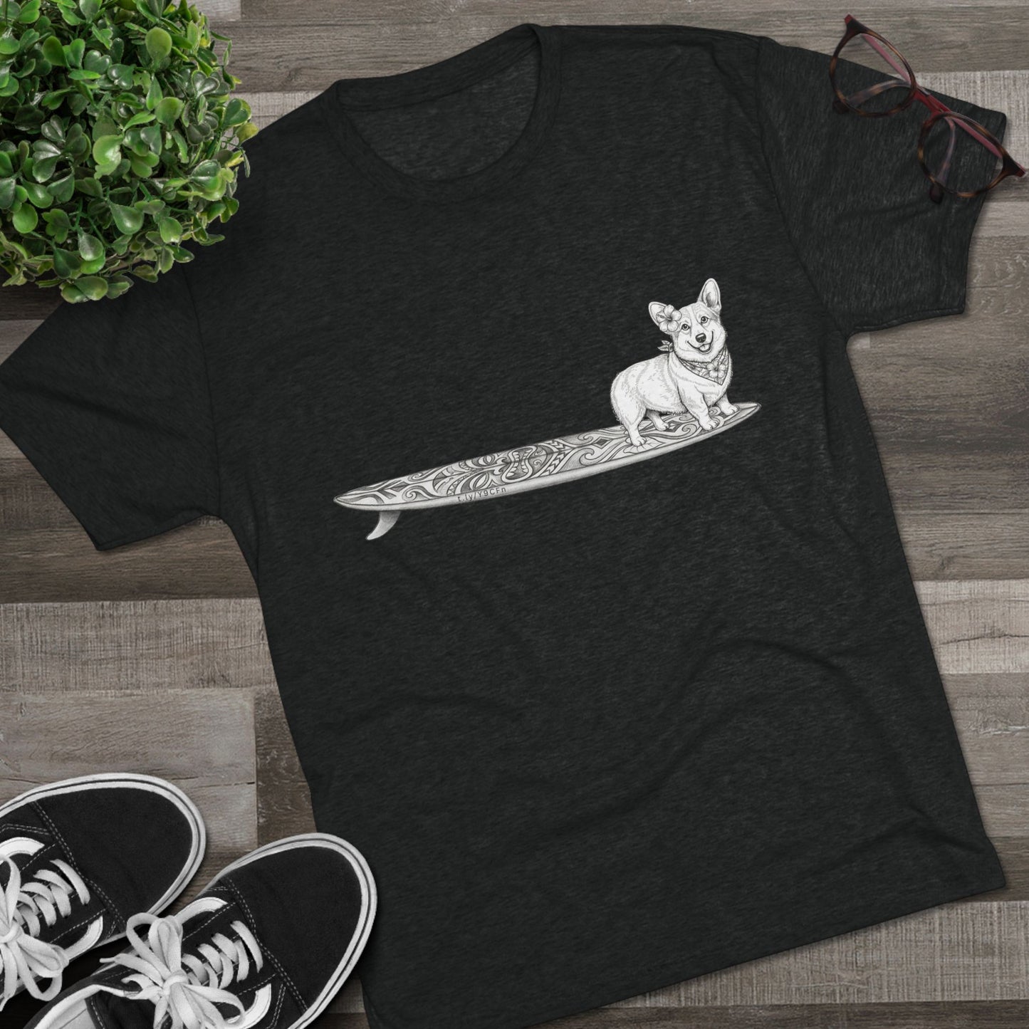 Black Corgi surf t-shirt with hibiscus bandana tiki surfboard design styled on wood floor with Vans sneakers — The Swell Dogs